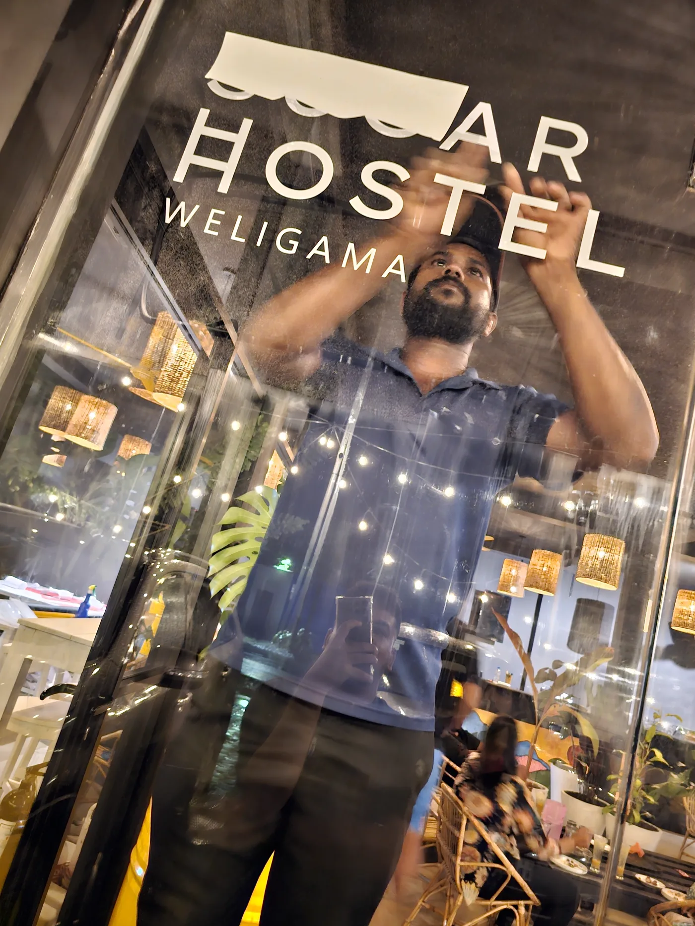 The black and yellow Sugar Hostel sign being installed in Weligama